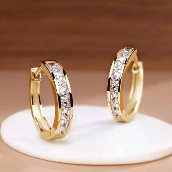 Schicke goldene und kristallene Creolen
